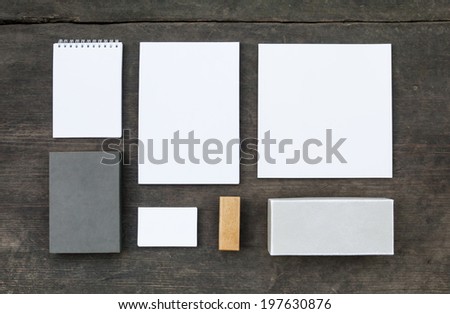Blank stationery set on wood background: business cards, booklet, sheets, notebook, stamp, and and old boxes (for branded souvenirs).