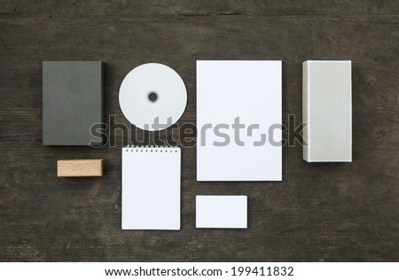 Blank stationery set on wood background: business cards, booklet, sheets, notebook, stamp, CD, and boxes. Retro style