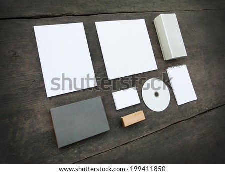 Blank stationery set on wood background: business cards, booklet, sheets, notebook, stamp, CD, and boxes. Retro style