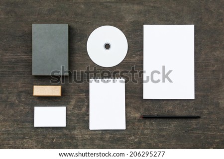Blank stationery set on old wood background: business cards, booklet, sheets, notebook, stamp, CD, and box. Retro style