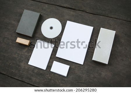 Blank stationery set on old wood background: business cards, booklet, sheets, notebook, stamp, CD, and boxes. Retro style