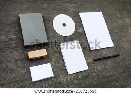 Blank stationery set on old wood background: business cards, booklet, sheets, notebook, stamp, CD, and box. Vintage style