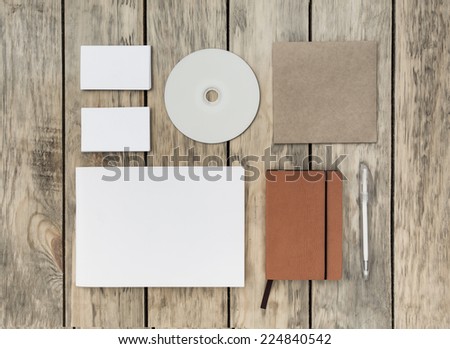 Blank stationery set on old wood background: business cards, booklet, notebook, notepad, CD, box and pen. Vintage style