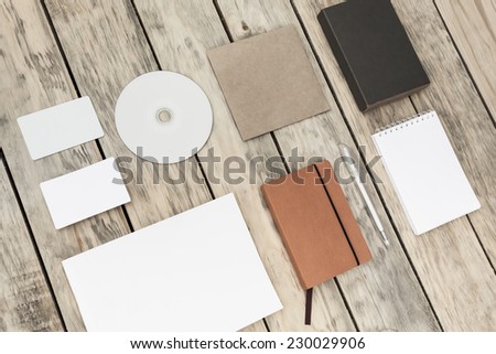 Blank stationery set on old wood background: business cards, plastic card, booklet, notebook, notepad, CD, box and pen. Vintage style