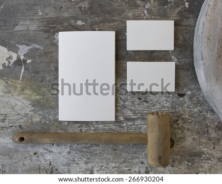 Blank business cards (two stacks) and booklet on a wooden grunge texture with a wooden mallet