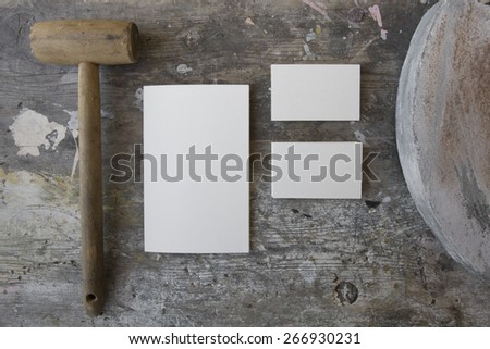 Blank business cards (two stacks) and booklet on a wooden grunge texture with a wooden mallet