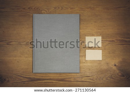 Blank book cover (booklet), and business cards on a wooden texture. Vintage style
