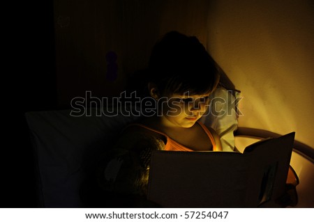 Girl reading a book with lamp