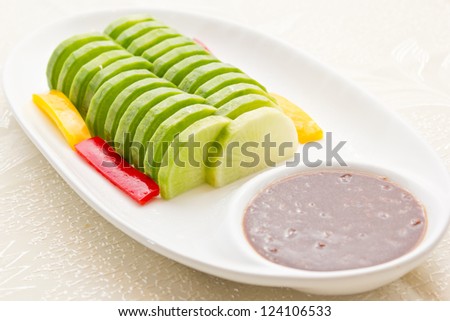 White radish slices on a plate, with a sweet sauce to eat together
