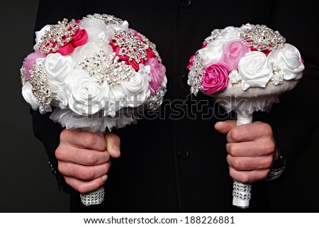 Man holds two wedding bouquet for bride
