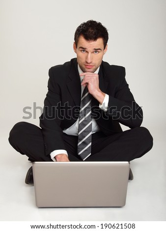 Handsome businessman at suit thinking at the computer