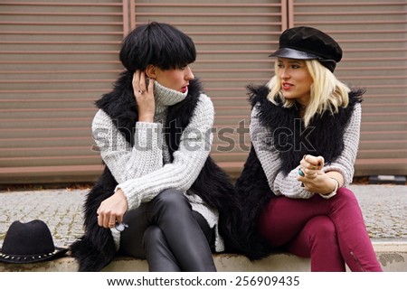 Two young attractive woman talks together outdoor