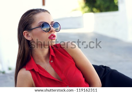 beautiful stylish girl in red blouse and sunglasses