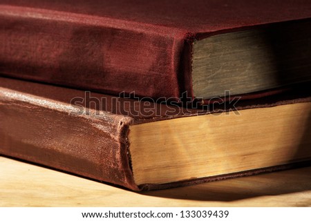closeup of two books lying on wooden table. shallow dof
