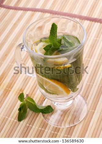 glass fresh water with mint and lemon on a bamboo table