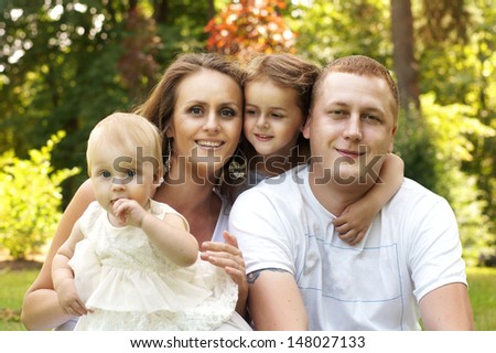 happy family. mother. father and two daughters hugging each other
