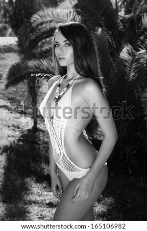 portrait of sexy lady in white bikini against palm trees