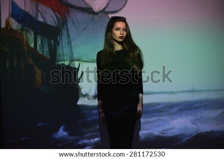 Art fashion portrait of young stylish girl in black clothes with painting on a screen