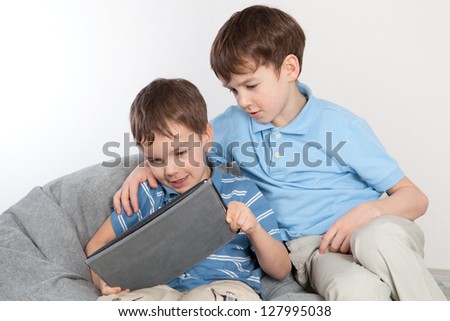 Two brothers playing on tablet, indoor