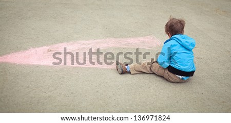 Boy drawing on road. Outdoor.