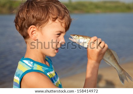 Young boy holding fish and smiling