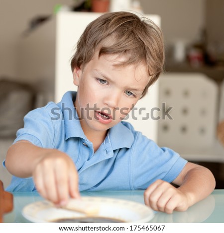Small boy makes a cake in kitchen