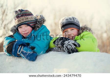 Portrait of two happy brothers in winter clothes, smiling boys on a walk in park, outdoor