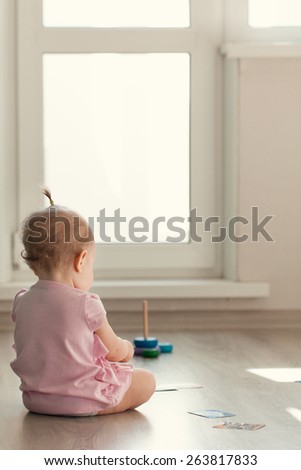 Little girl playing with pyramid on floor, kindergarten, precocity