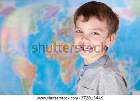 Portrait of happy child on background map of world