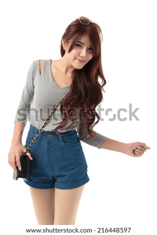 Asian woman posing in long sleeves slim fit top and denim shorts isolated with sling black bag on white  background.