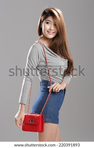 Asian woman pose in long sleeve deep v-neck drape top and high waisted denim shorts.