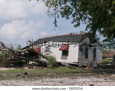 a house rests on a tree that it uprooted when carried by the floodwaters from the Industrial Canal levee breach - photo taken a year after Hurricane Katrina struck