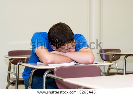 exhausted student takes a power nap in an empty classroom between final exams
