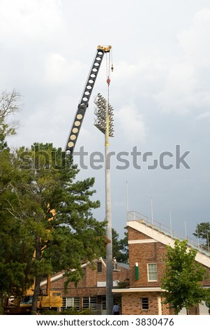 crane being used to install new lights on a college stadium