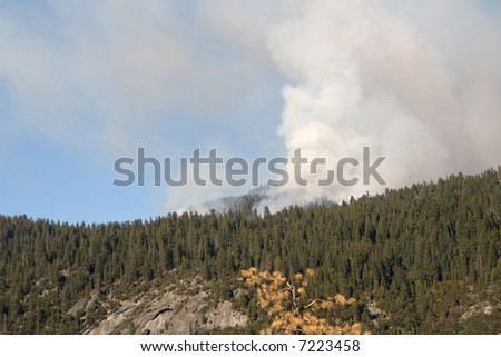 a forest fire caused by a lightning strike smolders on a mountainside in Yosemite National Park