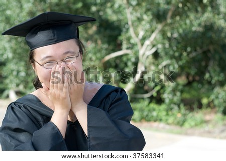Chinese college female in graduation gown laughing
