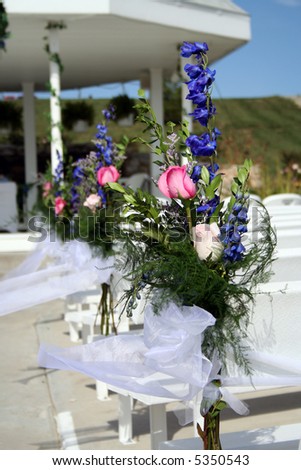stock photo Flower arrangements on the pews at a wedding