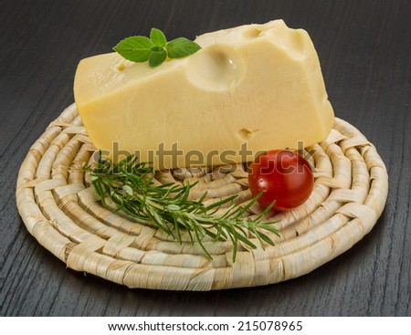 Maasdam cheese on the board with rosemary and mint