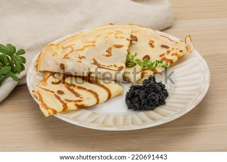 Pancakes with black caviar - russian style breakfast