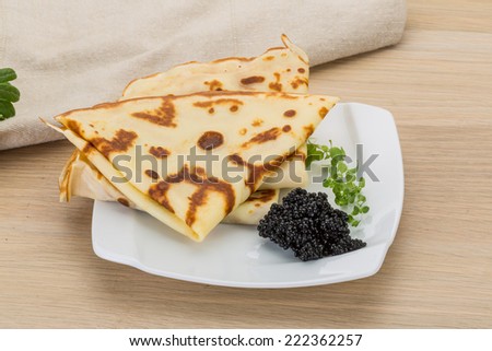 Pancakes with black caviar - russian style breakfast