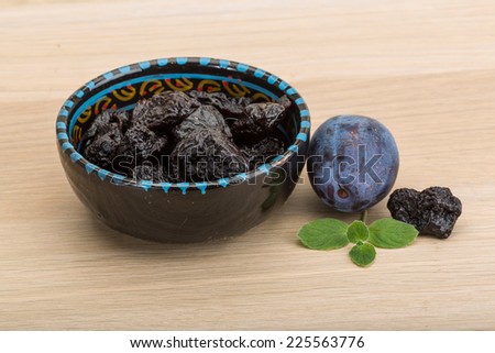 Dried plums in the bowl with fresh prune