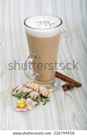 Cappuccino with pastry, cinnamon and flower