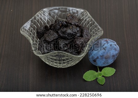 Dried plums in the bowl with fresh prune