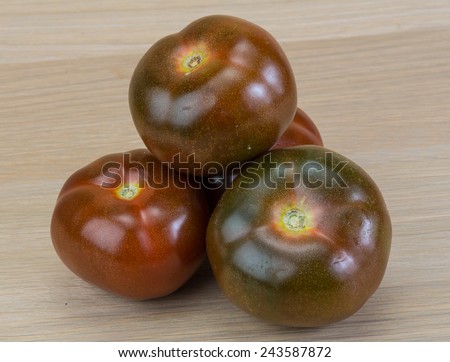 Black tomato - Kumato on the wood background