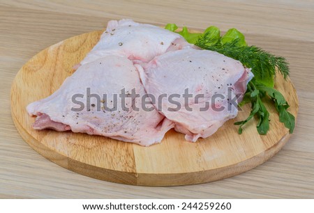 Raw chicken thighs with salad leaves and ruccola