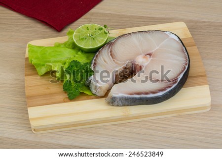 Raw blue shark steak with salad leaves and lime