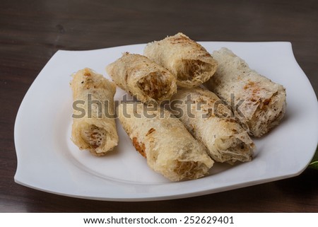Vietnamese Spring rolls with spicy sauce on wood background