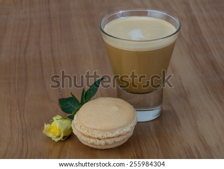 Coffee with macaroons and yellow rose flower