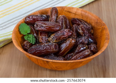 Dry Dates fruit in the bowl on the wood background