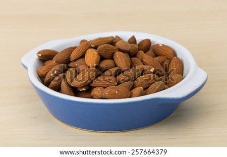 Roasted Almonds in the bowl on wood background